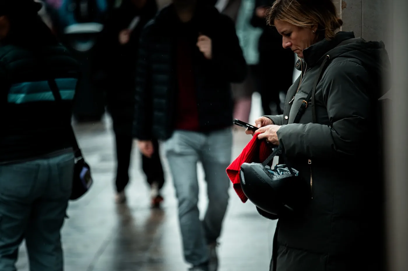 Mujer revisando su teléfono en medio de una calle concurrida